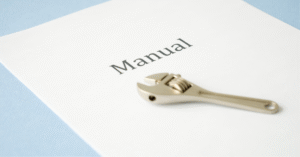 Llave inglesa sobre un manual que simboliza cómo crear procedimientos simples para microempresas